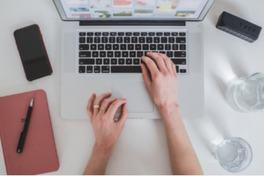 Homem sorrindo, criando um curso online em seu laptop moderno, com elementos gráficos de sucesso e monetização.