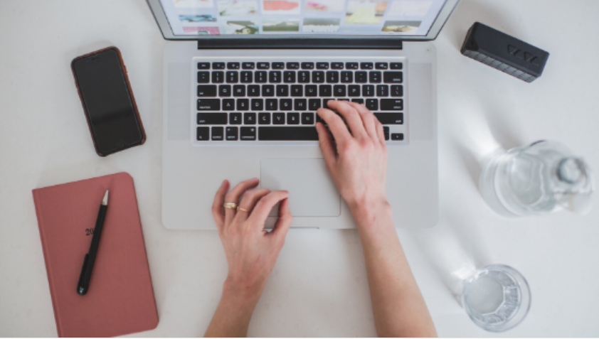 Homem sorrindo, criando um curso online em seu laptop moderno, com elementos gráficos de sucesso e monetização.