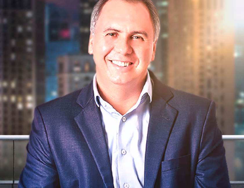 Marcos Trombetta em pose de sucesso, com fundo simbolizando riqueza e oportunidades, indicando download de ideias milionárias.