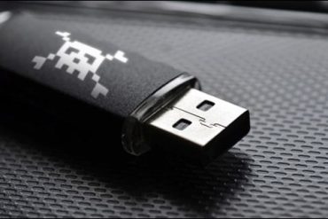 Pendrive com símbolo de hacker e código binário, representando download de curso de invasão