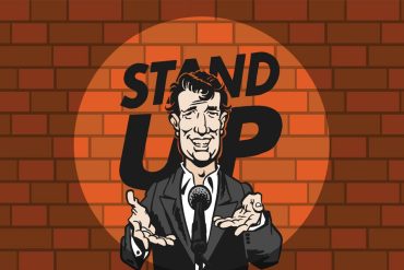Comediante em palco com microfone, praticando Stand Up Comedy.