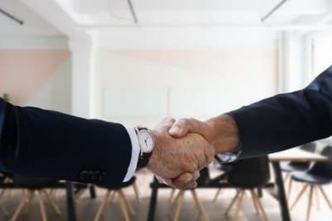 Curso de Recursos Humanos RB Treinamento com material de estudo e profissionais discutindo em um escritório moderno.