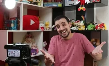 Homem sorrindo, filmando com câmera profissional, demonstrando o curso Profissão Youtuber de Diego Rox.